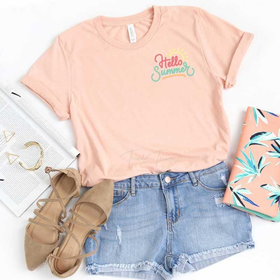 Hello Summer HAT/POCKET Screen Print Heat Transfer, casual summer outfit with pastel pink t-shirt featuring 'Hello Summer' print, denim shorts, beige sandals, and tropical patterned fabric.