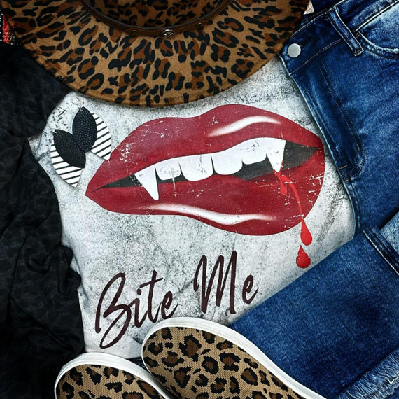 Bite Me Lips Halloween Screen Print Heat Transfer, graphic print of red lips with vampire teeth and blood drops, featuring black and white striped bat, on a textured background with jeans and leopard print shoes.
