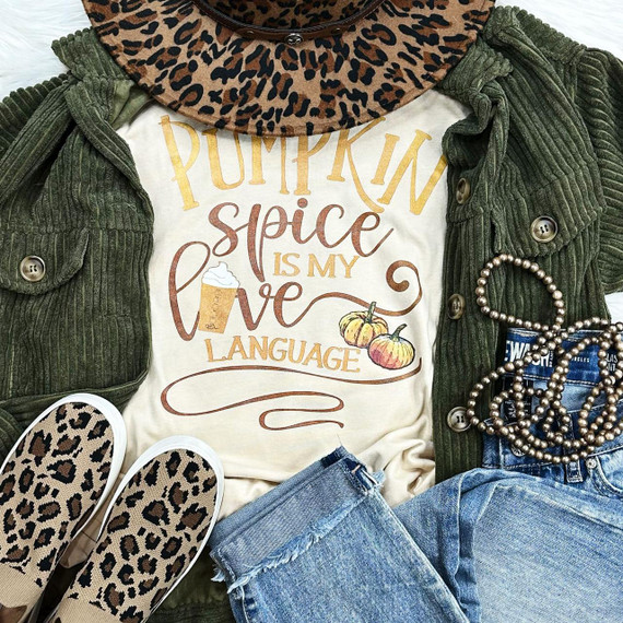 Pumpkin Spice Is My Love Language Screen Print Transfer, creative fall-themed shirt design with pumpkins and pumpkin spice latte, surrounded by a green corduroy jacket, leopard print slip-on shoes, blue denim shorts, and jewelry.