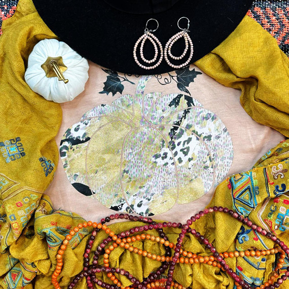 Leopard Pumpkin FINAL STOCK Screen Print Transfer, colorful pumpkin design with leopard print accents on a fabric background surrounded by vibrant wool scarves and jewelry.