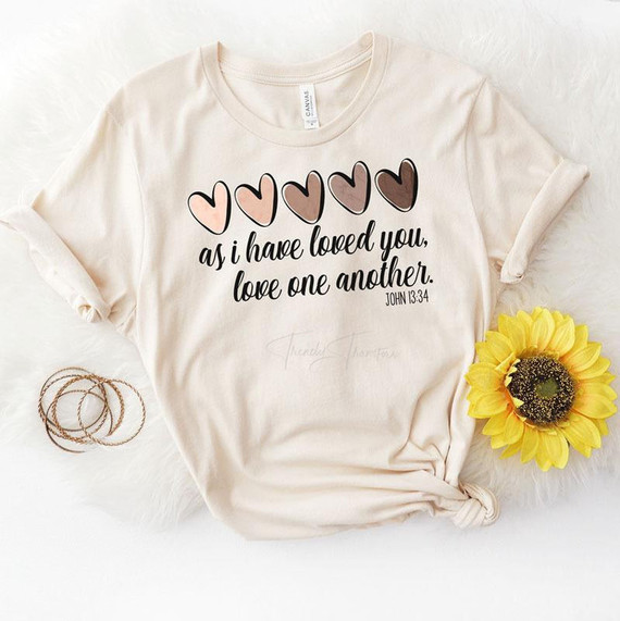 Love One Another Screen Print Heat Transfer T-shirt, cream-colored T-shirt with heart-shaped designs and a quote from John 13:34.