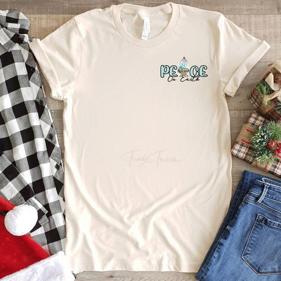 Peace On Earth HAT/POCKET Screen Print Heat Transfer, off-white t-shirt with holiday-themed design including a hat and globe illustration with text.