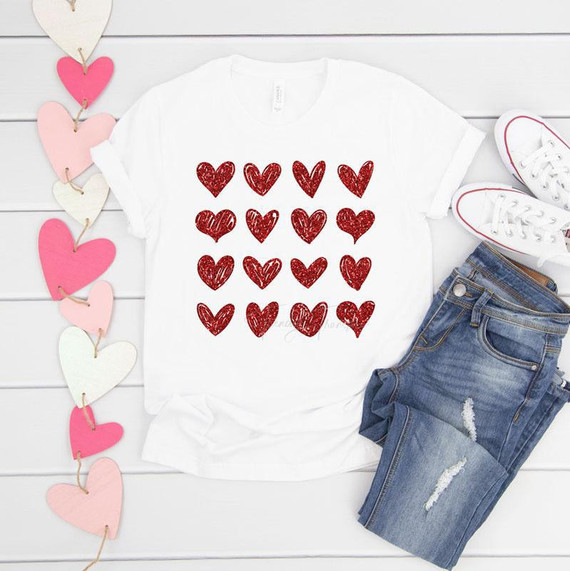Red Glitter Hearts Sublimation Transfer, a pattern of shiny red heart shapes on a white T-shirt displayed flat with jeans and sneakers.