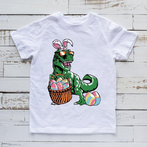 T-Rex With Easter Eggs Sublimation Transfer, colorful T-Rex holding a basket of Easter eggs with additional eggs on the ground.