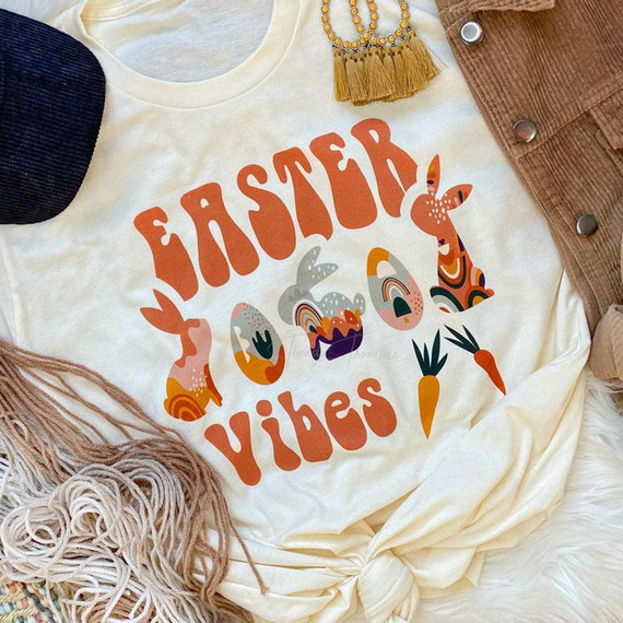 Easter Vibes Boho Screen Print Heat Transfer, colorful Easter-themed boho design on a beige T-shirt with rabbits, carrots, and vibrant patterns expressing festive vibes.