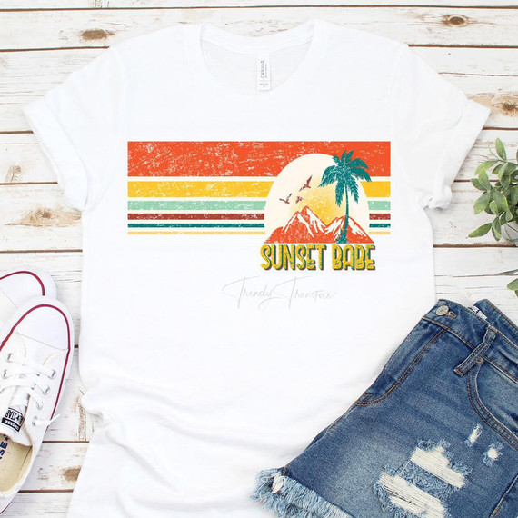 Sunset Babe Sublimation Transfer, colorful vintage style sunset design with mountains, palm tree, and birds on a white t-shirt.