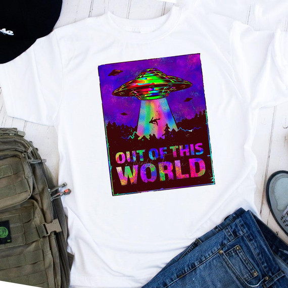 Out Of This World Sublimation Transfer on a white T-shirt, featuring a colorful UFO beaming up a person with galaxy and mountain background.