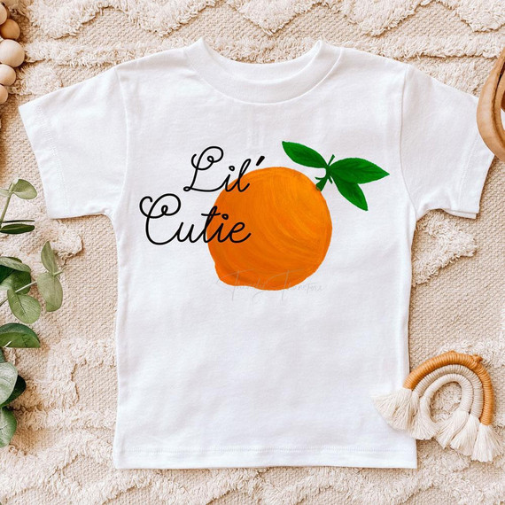 Lil' Cutie Sublimation Transfer, orange fruit design with green leaves on a white children's T-shirt.
