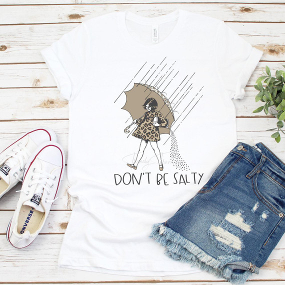 Don't Be Salty Leopard Sublimation Transfer, white T-shirt with a graphic of a woman holding an umbrella in the rain, wearing a leopard print coat and the text 'DON'T BE SALTY' underneath.