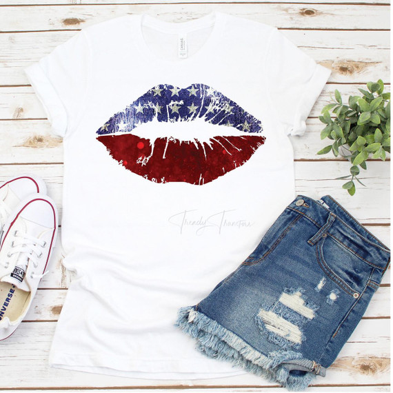 Patriotic Lips Sparkle Stars Red White and Blue Sublimation Transfer, American flag-themed lip design on a white T-shirt with distressed denim shorts and white sneakers on a wooden surface.