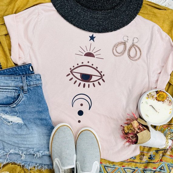 Moon & Stars Screen Print Heat Transfer, artistic celestial design on a pink t-shirt with eye, moon, sun, star, and moon phases motifs.