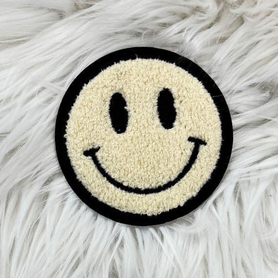 Chenille Smile Face Embroidered Sticker, a round patch featuring a cheerful smiley face with black eyes, a curved smiling mouth, and outlined in black on a soft, fluffy white background.