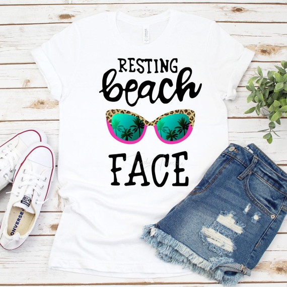 Resting Beach Face Sublimation Transfer, white t-shirt with a printed design of sunglasses with palm trees and tropical scenery reflecting in the lenses.