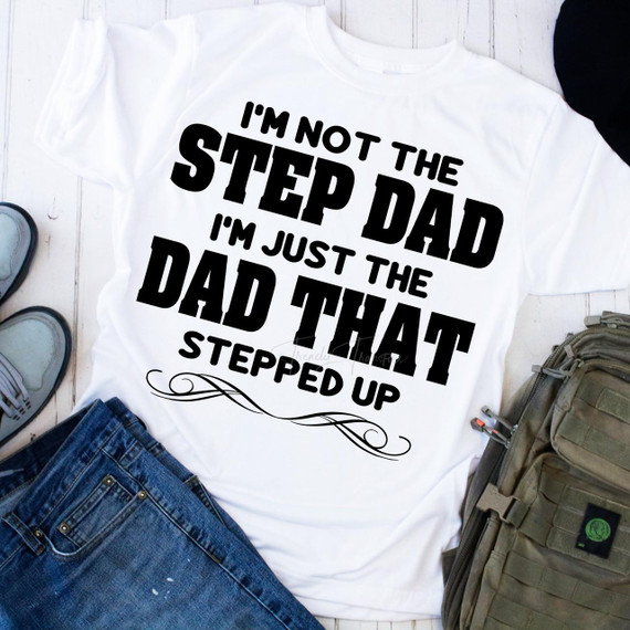 I'm Not the Step Dad I'm The Dad Who Stepped Up BLACK Sublimation Transfer, white T-shirt with bold black text and decorative swirl at the bottom.
