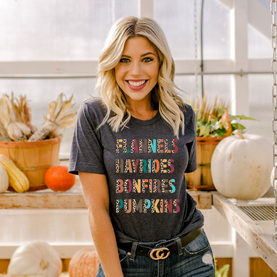 Flannels Hayrides Bonfires Pumpkins Leopard DTF Heat Transfer, a woman wearing a dark T-shirt with colorful leopard print text for fall-themed design.
