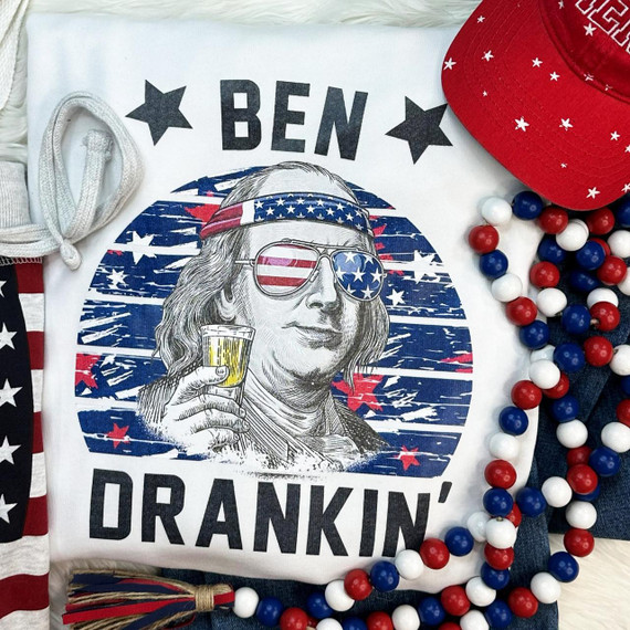 Ben Drankin' Screen Print Heat Transfer, patriotic-themed graphic t-shirt featuring a cartoon of a woman with sunglasses and a drink, with red, white, and blue colors and stars.