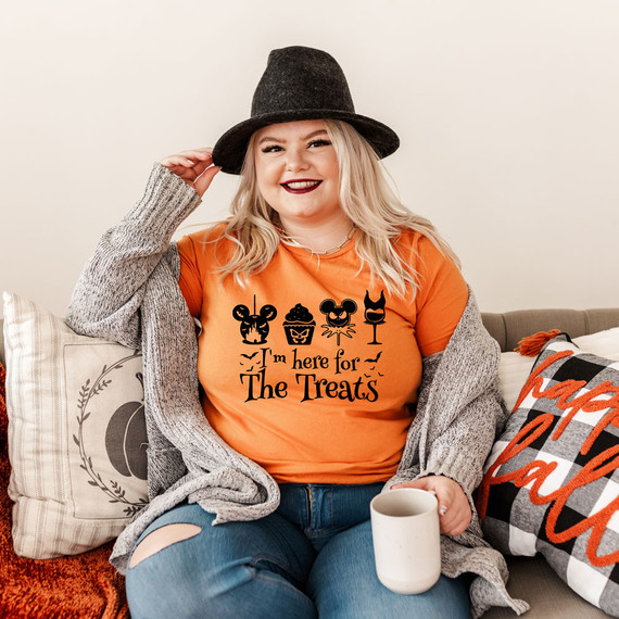 I'm Here For The Treats Screen Print Heat Transfer on a woman wearing an orange t-shirt with Halloween-themed icons and text.