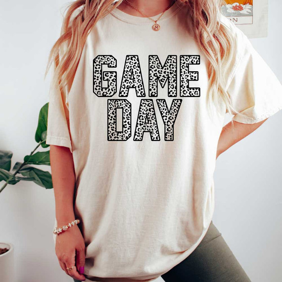Game Day Leopard DTF, a white women's T-shirt with a bold 'GAME DAY' text printed in black and white leopard print pattern across the front.
