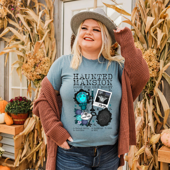 Spooky Mansion DTF Transfer, woman wearing a haunted house-themed t-shirt with Halloween decorations in the background.