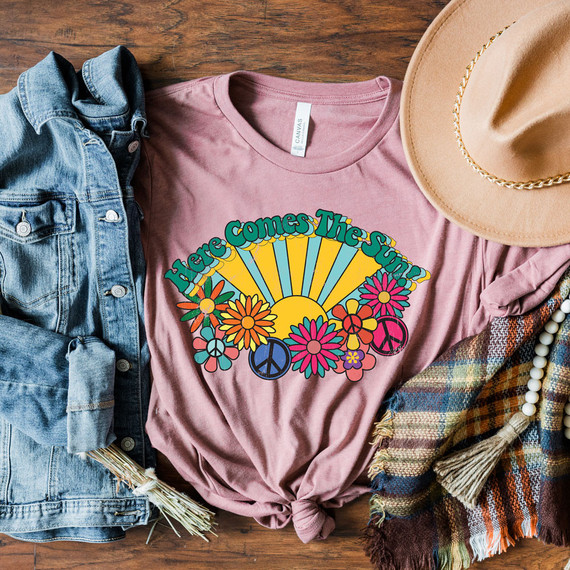 Here Comes The Sun DTF Transfer, colorful vintage-inspired T-shirt with sun, flowers, and peace symbols design.