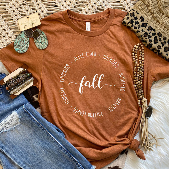 Fall DTF Transfer, image showing a rust-colored t-shirt with fall-themed words and a circle of seasonal terms around the word 'fall'.