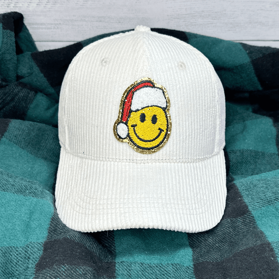 Santa Smile Embroidered Patch, smiling yellow face with Santa hat embroidered patch on white cap.
