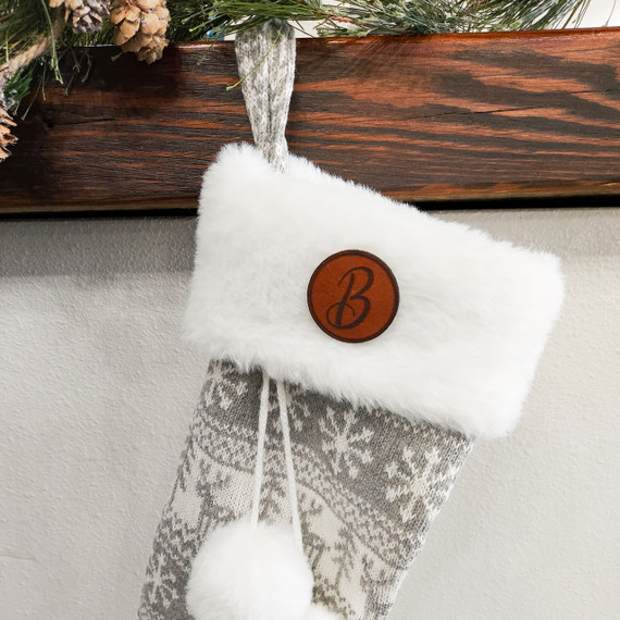 Custom Initial Brown Leather Patch Christmas Stocking, front view of a cozy Christmas stocking with a brown leather patch embroidered with a letter, hanging from a decorative hook.
