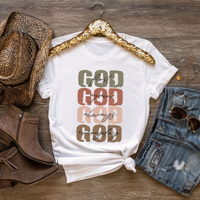 God First God Everyday Screen Print Heat Transfer T-Shirt, white casual T-shirt with motivational text, surrounded by fashion accessories, jeans, sunglasses, and a handbag on a wooden surface.