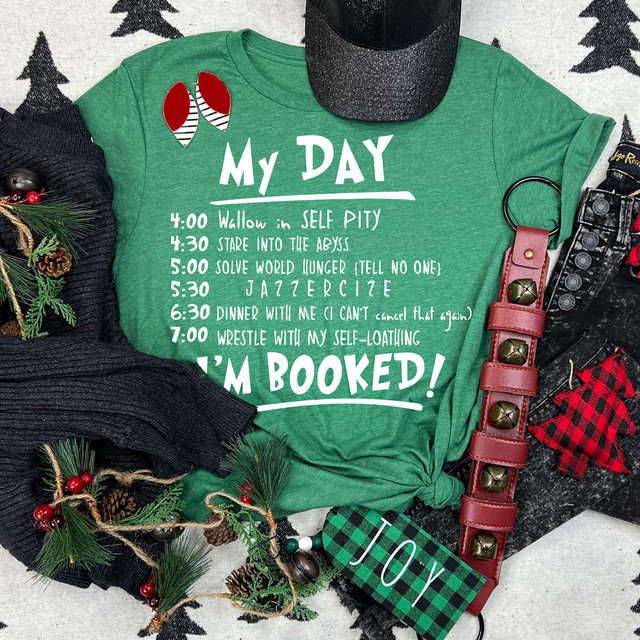 My Day I'm Booked WHITE DTF Heat Transfer, Christmas-themed green T-shirt with humorous daily schedule printed on it.
