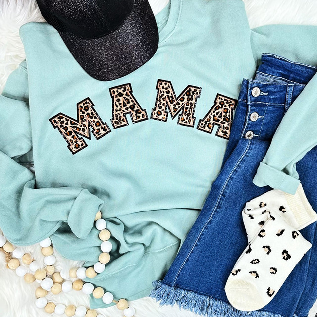 LEOPARD Chenille Embroidered Patch MAMA, stylish garment with leopard print chevron embroidery on a mint green sweatshirt, paired with blue jeans, a black glittery hat, and animal print socks.