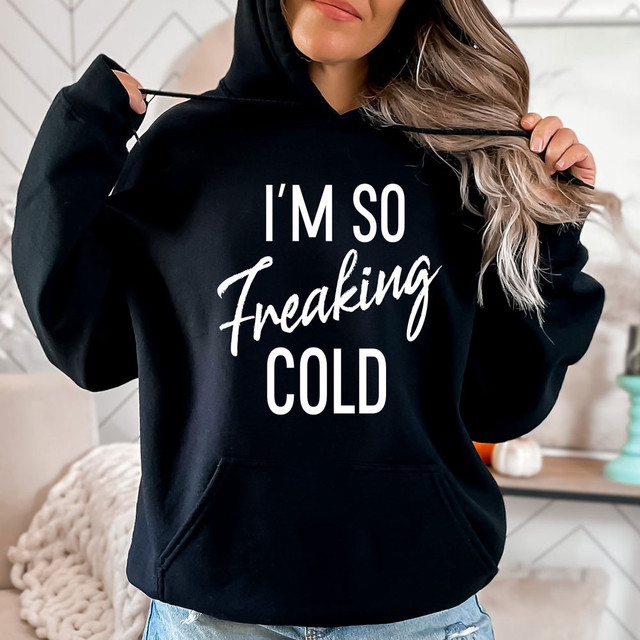 I'm So Freaking Cold WHITE DTF Heat Transfer, product image showing a woman wearing a black hoodie with white text design.