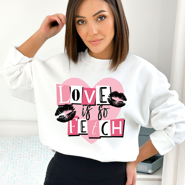 Love Is So Fetch DTF Heat Transfer, graphic design with pink heart, black lipstick kisses, and bold mixed letter fonts on a white sweatshirt.