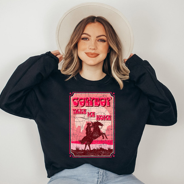 Cowboy Take Me Home DTF Heat Transfer, a woman wearing a black sweatshirt with pink and red cowboy-themed graphics and text, featuring a silhouette of a cowboy on a horse.