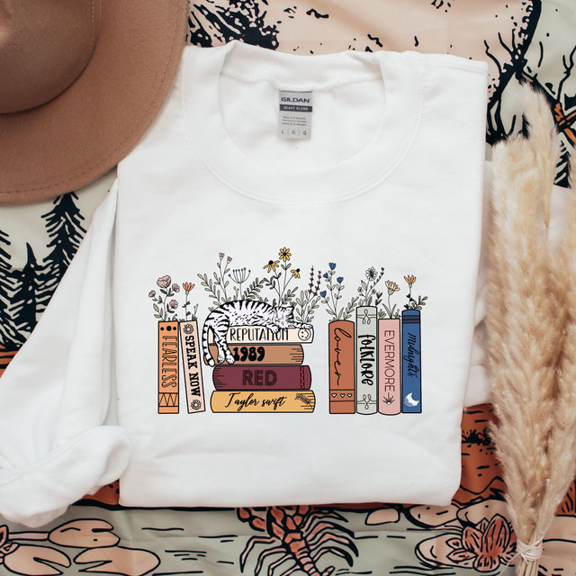 Reading Books DTF Heat Transfer, white T-shirt with a colorful book-themed design featuring books, a tiger, and floral elements.