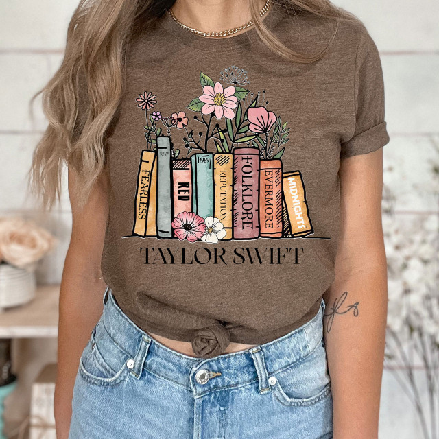 Taylor Books DTF Heat Transfer, colorful book-themed graphic design on a brown t-shirt with flowers and text.