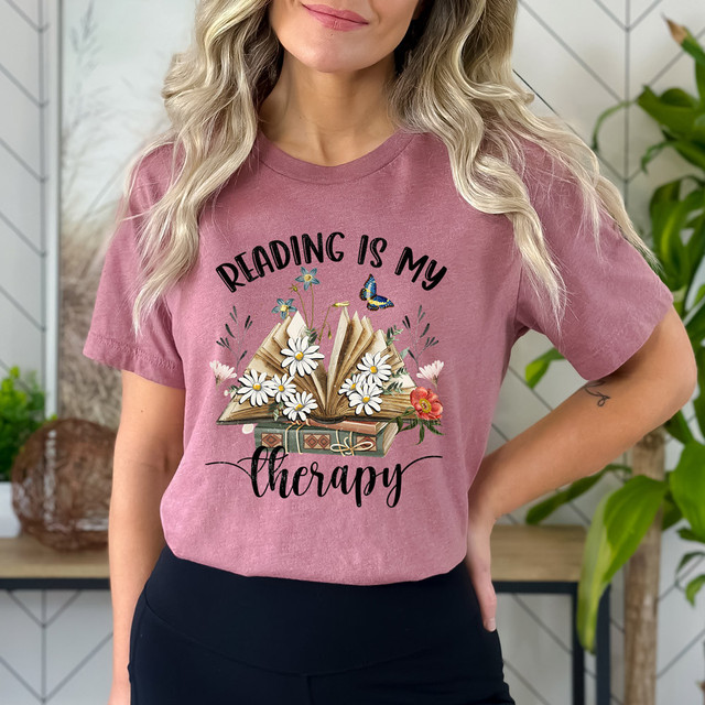 Reading Is My Therapy DTF Heat Transfer, colorful design featuring an open book with flowers and butterflies on a pink t-shirt.
