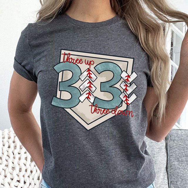 Three Up Three Down DTF Heat Transfer, graphic design of the number 33 with baseball arrows and the words "three up" and "three down" on a women's gray T-shirt.
