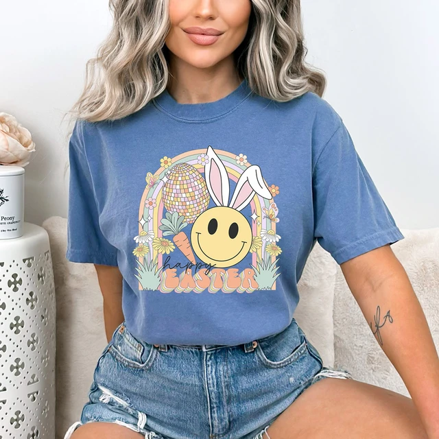 Happy Easter Retro DTF Heat Transfer, colorful Easter-themed design with a smiling bunny face, rainbow, and floral elements on a blue t-shirt.