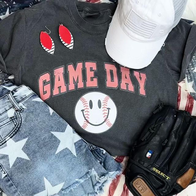 Game Day Retro Screen Print Heat Transfer, showing a graphic t-shirt with a baseball smiley face and retro text, alongside accessories like earrings, a cap, jeans, and a baseball glove.