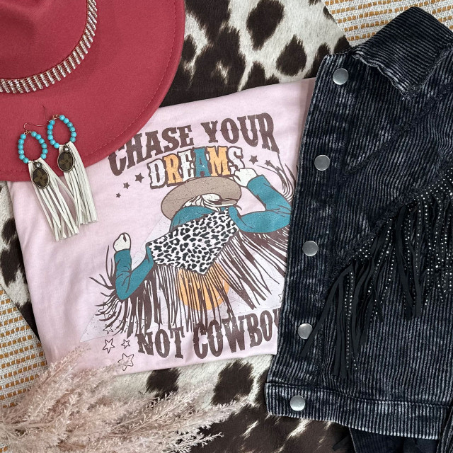Chase Dreams Screen Print Heat Transfer, a graphic design featuring a cowgirl with a cowboy hat, leopard print face mask, and the text "Chase Your Dreams Not Cowboys" printed on a pink T-shirt.