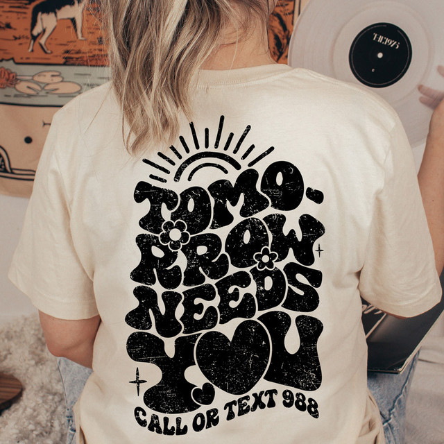 Tomorrow Needs You DTF Heat Transfer, a black graphic design on a white t-shirt showing a stylized sun, flowers, and heart with text elements