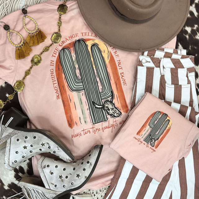 Something In The Orange Cactus Screen Print Heat Transfer on a pink T-shirt, with accompanying clothing and accessories in the image.
