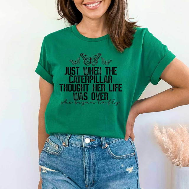 She Began To Fly DTF Heat Transfer, woman wearing a green t-shirt with butterfly and caterpillar design and inspirational quote.