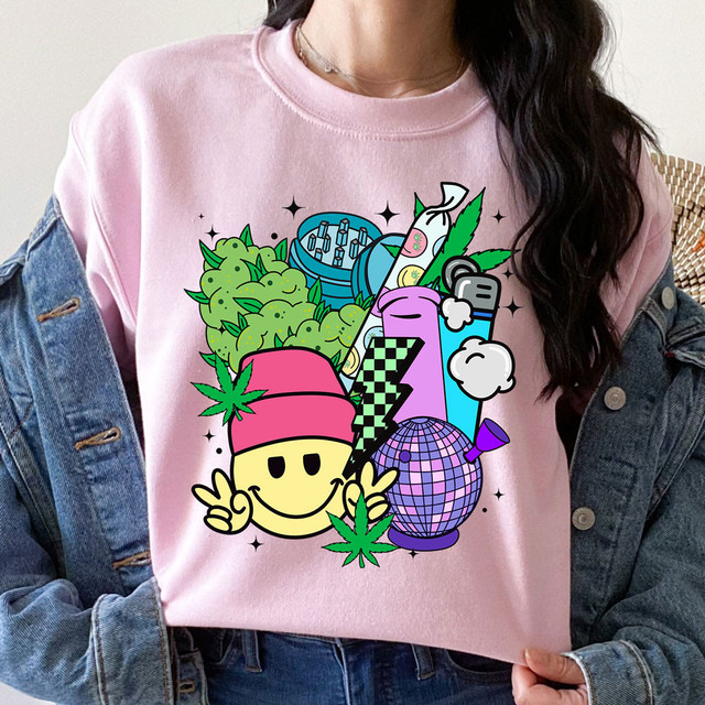 420 Collage DTF Heat Transfer, colorful and vibrant graphic design featuring various pop culture and cartoon elements on a pink sweatshirt.