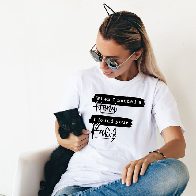 When I Needed A Hand I Found Your Paw DTF Heat Transfer, a woman holding a black kitten and wearing a white t-shirt with humorous text and sunglasses.