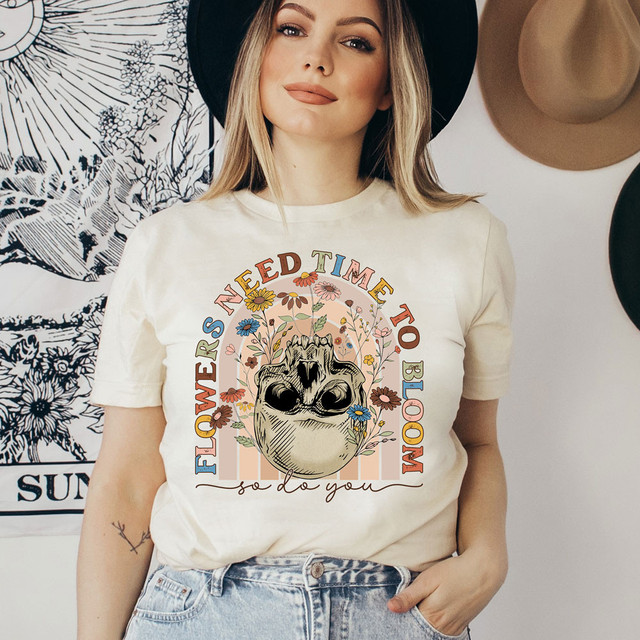 Flowers Need Time To Bloom So Do You DTF Heat Transfer, a woman wearing a graphic t-shirt with floral and anatomical design.