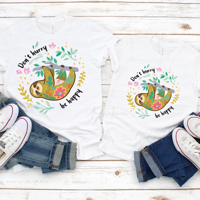 Don't Hurry Be Happy Sloth Sublimation Transfer, adorable sloth illustration on white T-shirts with floral decorations and cheerful message.