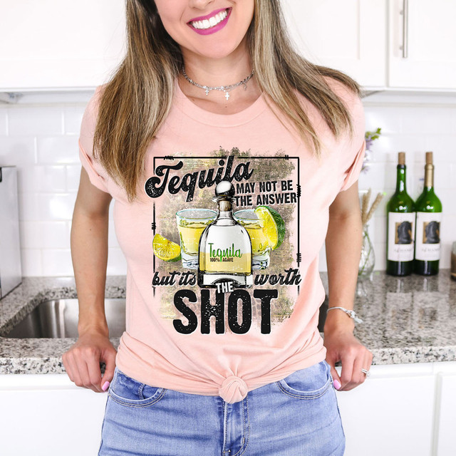 Tequila May Not Be The Answer But It's Worth A Shot DTF Heat Transfer T-shirt worn by a woman in a kitchen setting.