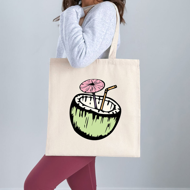 Coconut Drink DTF Heat Transfer, illustration on tote bag of a coconut with a pink umbrella and a straw.