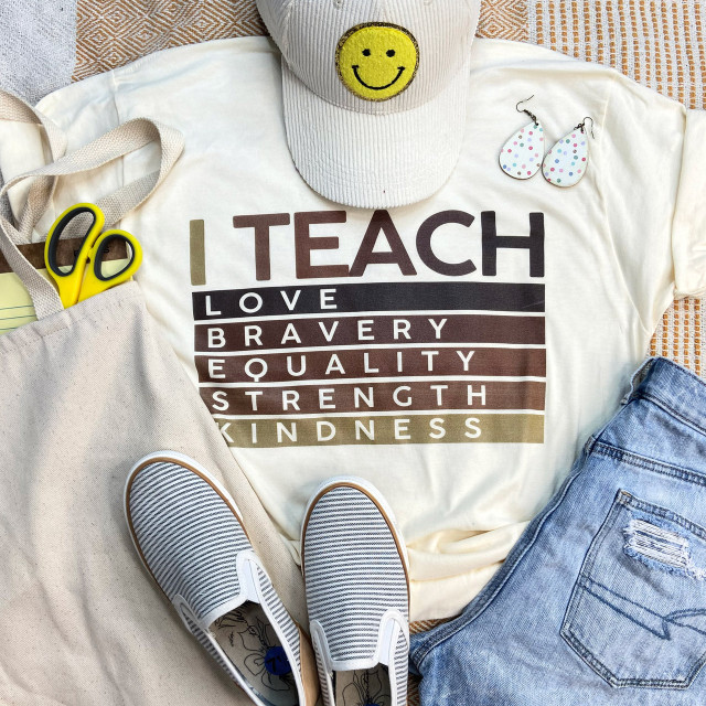 I Teach Love Equality Kindness Screen Print Heat Transfer, a white t-shirt with colorful text displaying the message.